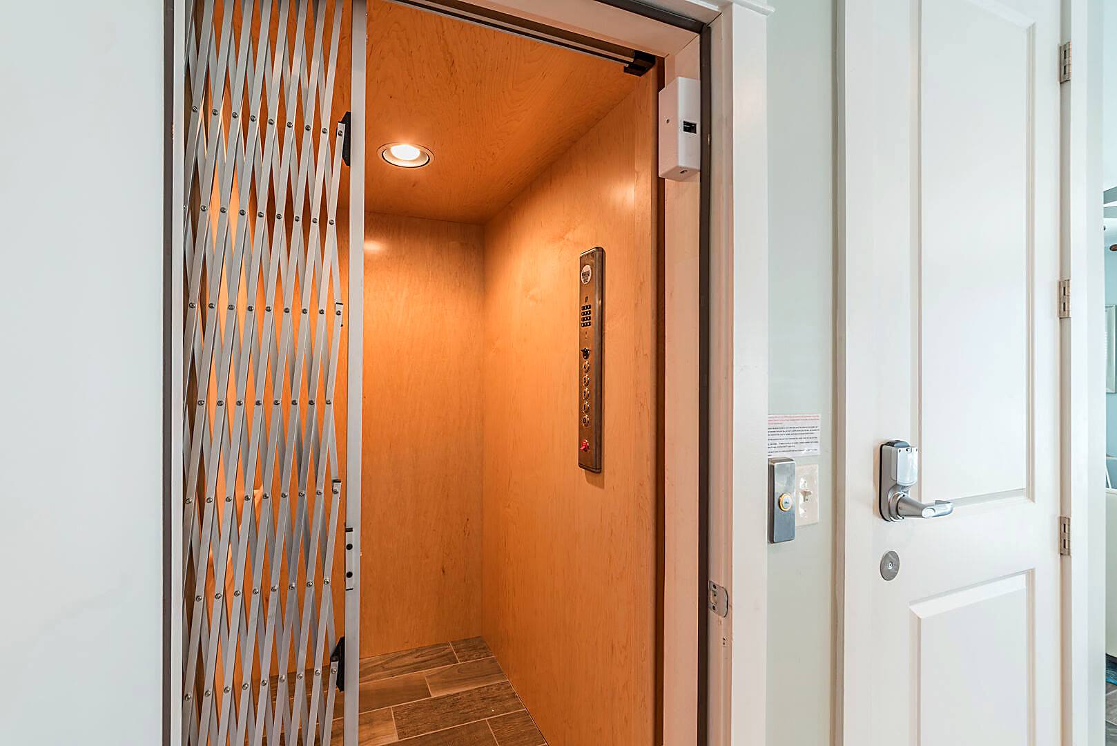 Interior of the residential elevator at 122 Sandcastle Court with wood panelling and accordion gate