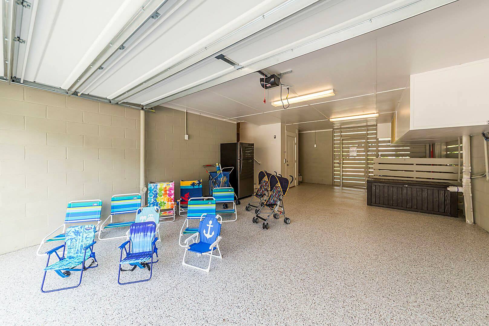 Garage at 122 Sandcastle Court stocked with beach chairs, a beach cart, two strollers and a second refrigerator