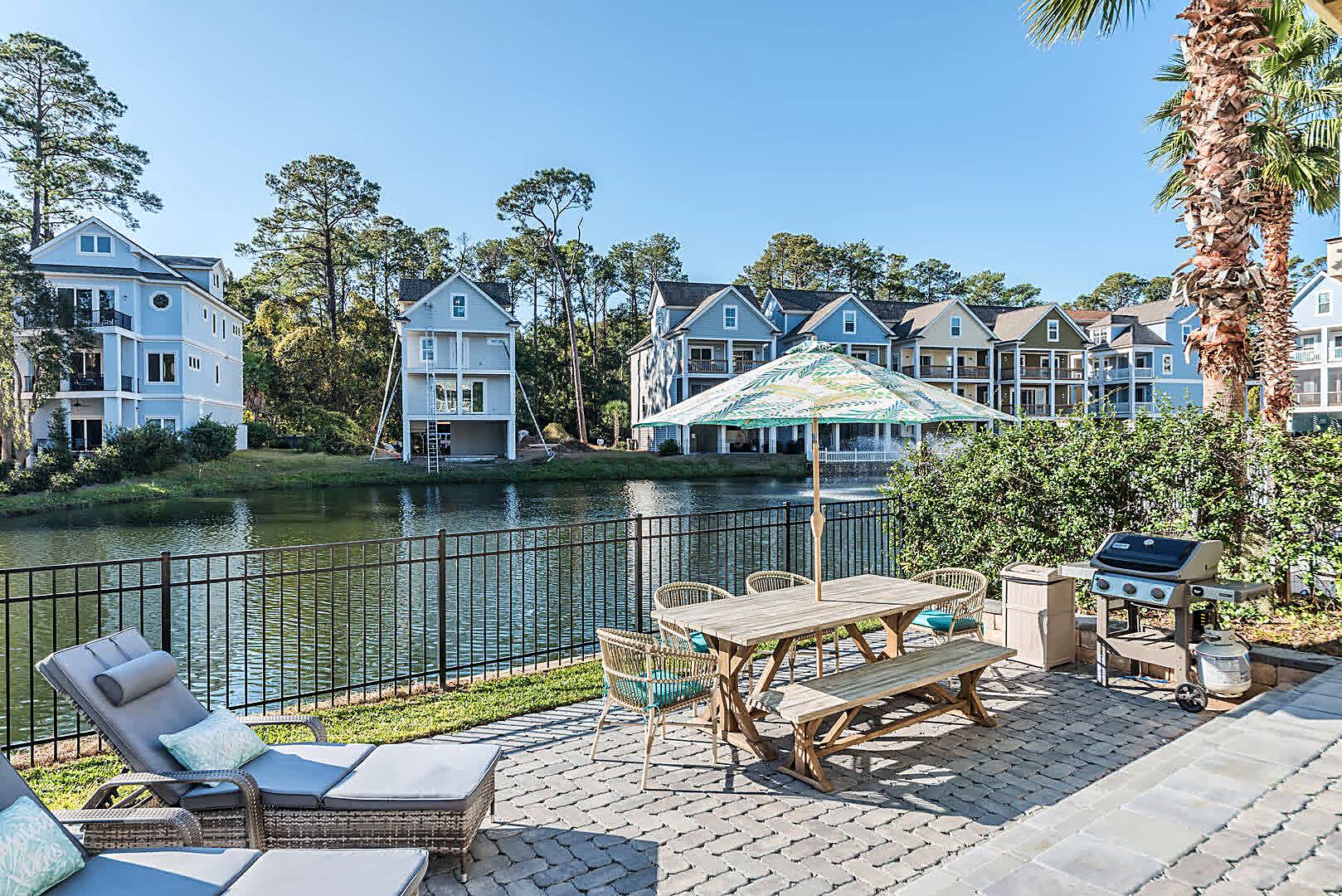 Sun loungers, outdoor dining and the gas grill beside the lagoon at 122 Sandcastle Court, Hilton Head Island