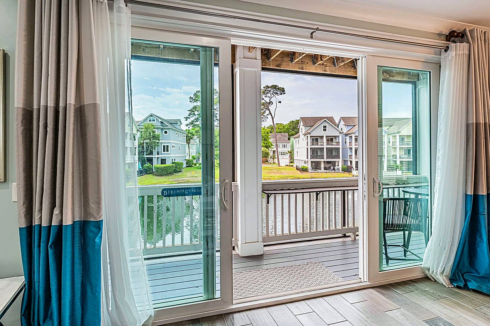 Twelve-foot sliding glass doors opening from the living room onto the screened porch and the lagoon at 122 Sandcastle Court